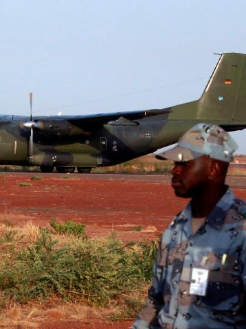 Malian soldiers stand guard while the first German military transall C-160 cargo lands in Bamako...