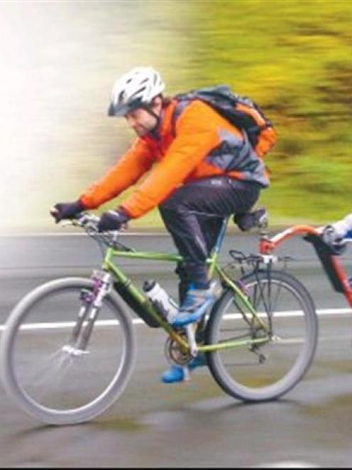 Malin Dunroy (5) gets a tow along Portobello Rd, from his father, Norman, as they cycle from...