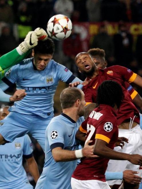 Manchester City goalkeeper Joe Hart (L) makes a save during their Champions League match against...