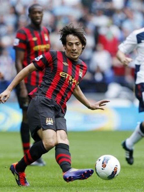 Manchester City's David Silva, centr, passes the ball against Bolton during their English Premier...
