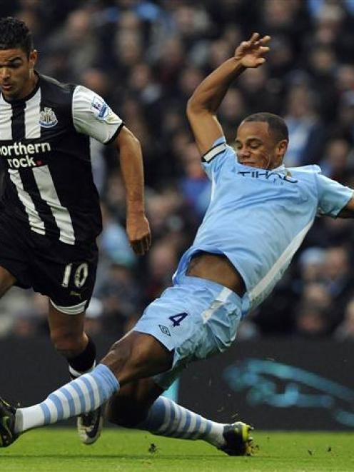 Manchester City's Vincent Kompany challenges Newcastle United's Hatem Ben Arfa. REUTERS/Nigel Roddis