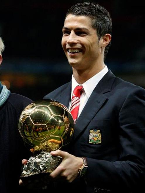 Manchester United's Cristiano Ronaldo (centre) holds the Ballon d'Or trophy, as former Manchester...
