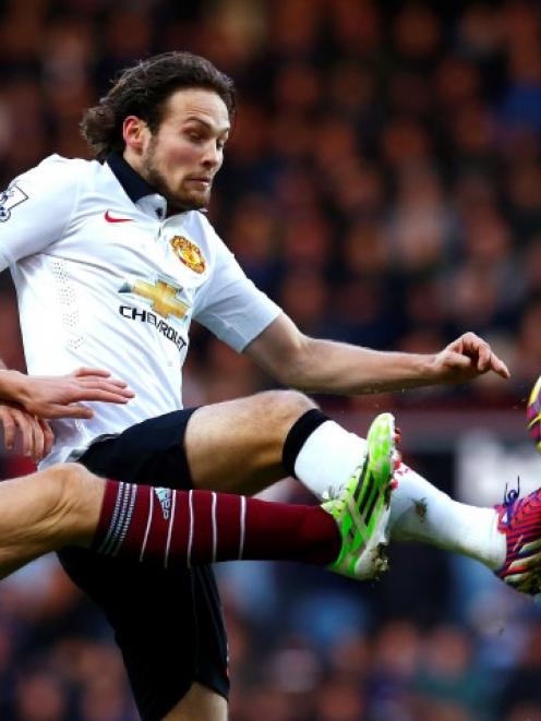 Manchester United's Daley Blind (R) challenges West Ham United's Stewart Downing during their...