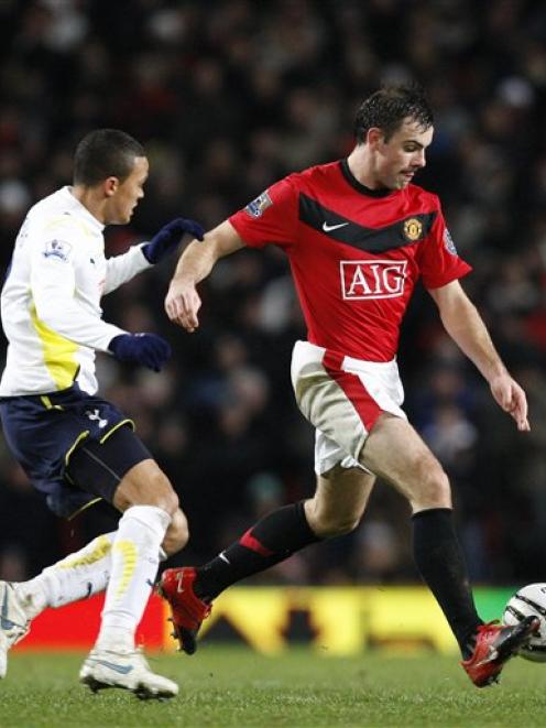 Manchester United's Darron Gibson, right, fights for the ball against Tottenham's Jermine Jenas...