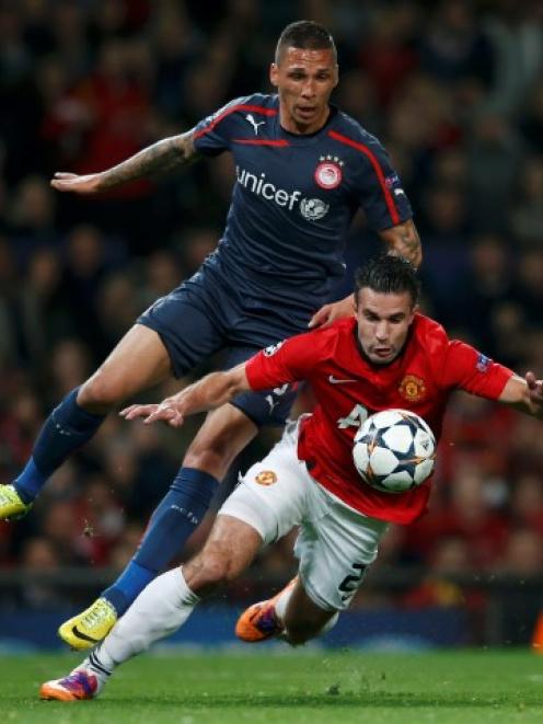 Manchester United's Robin van Persie (front) is fouled for penalty by Olympiakos' Jose Holebas....