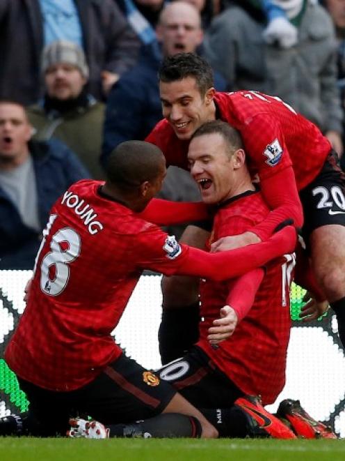 Manchester United's Wayne Rooney (C) celebrates scoring against Manchester City with Robin Van...
