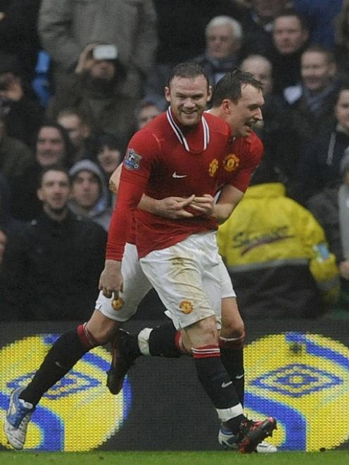 Manchester United's Wayne Rooney (L) celebrates his second goal against Manchester City with Phil...
