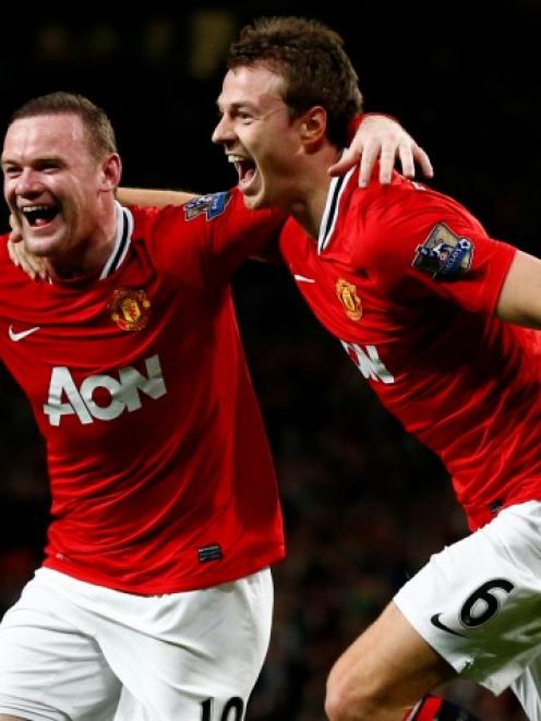 Manchester United's Wayne Rooney (L) celebrates his goal against Fulham with Jonny Evans during...