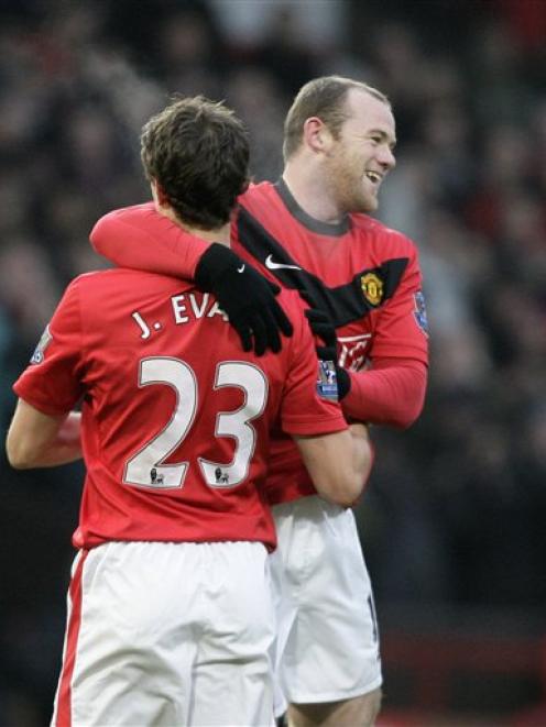 Manchester United's Wayne Rooney, right, celebrates with teammate Jonny Evans after scoring...