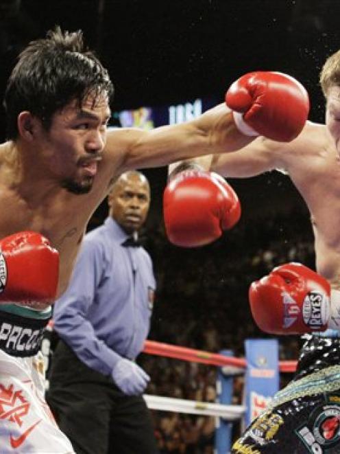 Manny Pacquiao, of the Philippines, left, throws a left to the head of British boxer Ricky Hatton...