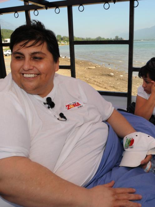 Manuel Uribe, better known as "Meme", left, who weights around 310kg, smiles while his girlfriend...