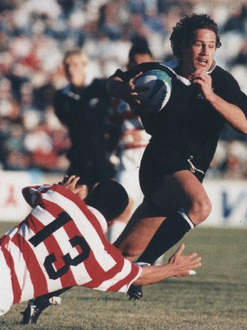 Marc Ellis brushes past a Japanese defender in 1995. Photo by The New Zealand Herald.