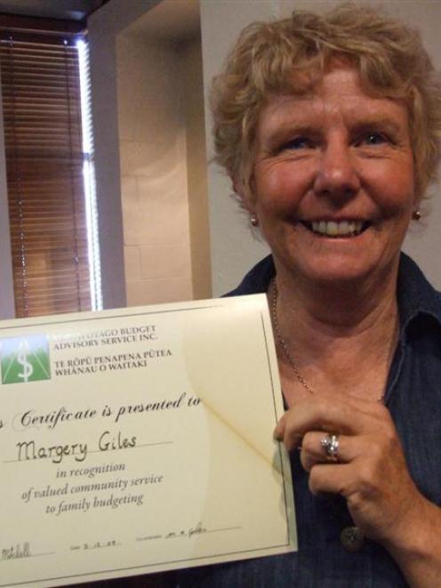 Marge Giles holds a certificate acknowledging her 25 years of service to the North Otago Budget...