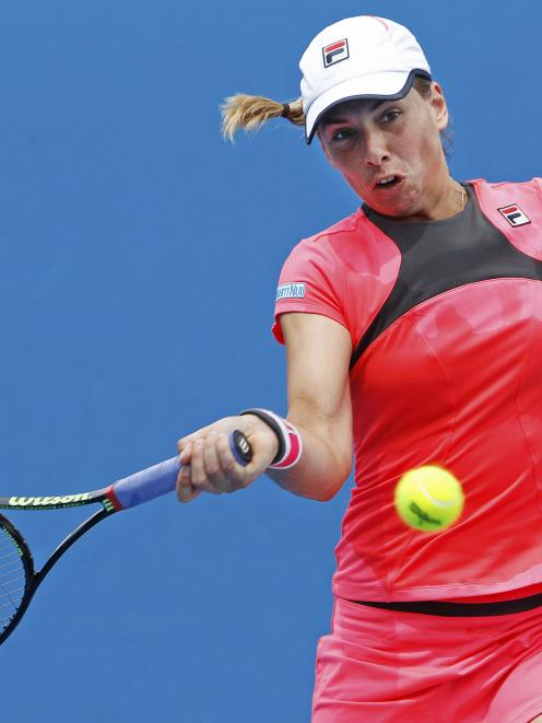 Marina Erakovic of New Zealand hits a return to Garbine Muguruza of Spain during their women's...