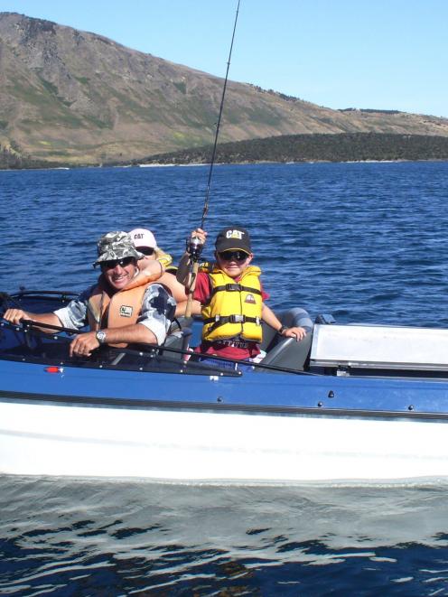 Mark and Joanna Hacquoil, with their son Jake, fishing on Lake Wanaka recently. Photo supplied.