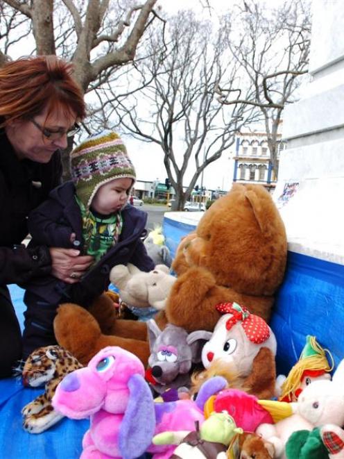 Mary Sharp and her grandson Leeroy Gillon-Reynolds (6 months) place a teddy bear at the base of...