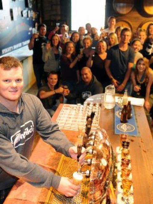 Mathew Beard (27), of Sydney, learns to pour a beer while his Contiki tour party group samples...