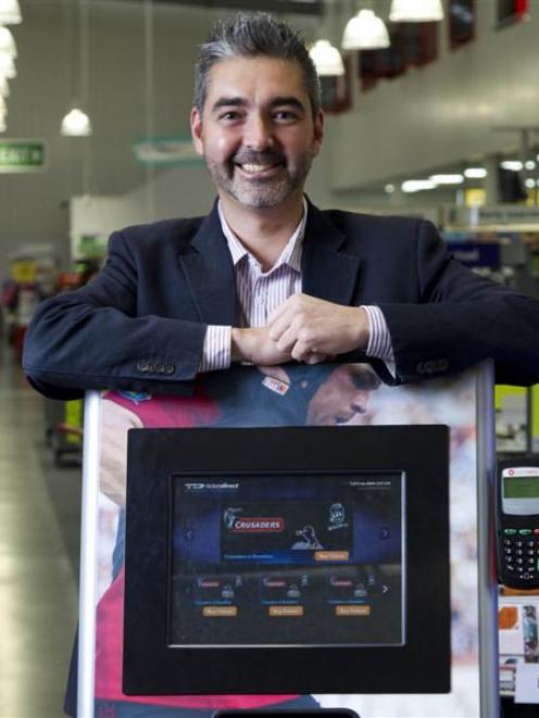 Matthew Davey, managing director of TicketDirect, stands behind an unmanned ticketing kiosk....