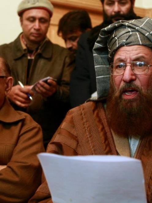 Maulana Sami ul-Haq (R), a Taliban negotiator, reads a joint statement with Irfan Siddiqui, a...