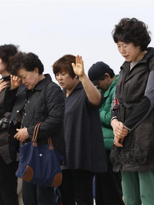Members of a Christian group pray for missing passengers who were on the South Korean ferry Sewol...