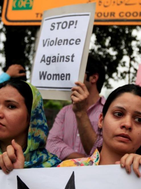 Members of civil society and the Human Rights Commission of Pakistan hold placards during a...