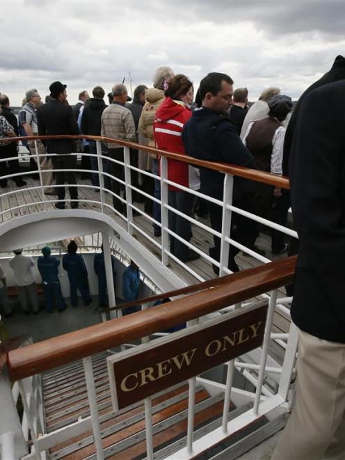 Members of the crew are seen at the deck below partying guests as the Titanic Memorial Cruise...