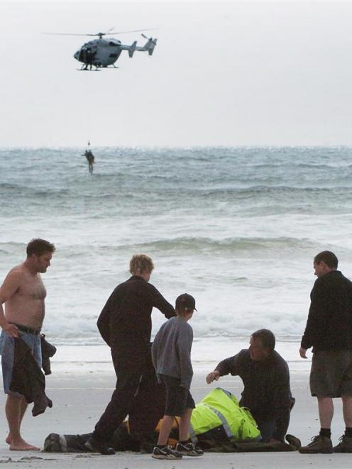 Members of the public assist emergency services staff by bringing blankets to help warm those...