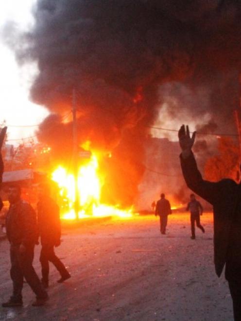 Men react near a site hit by what activists say are barrel bombs dropped by government forces on...