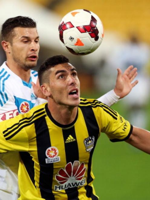 Michael Boxall of the Phoenix holds off the challenge of the Victory's Kosta Barbarouses. Photo...