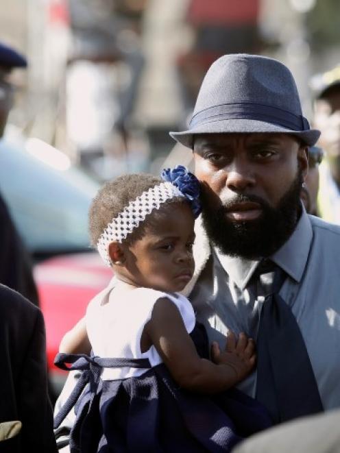 Michael Brown Sr. (in hat) attends the funeral for his son Michael Brown at Friendly Temple...