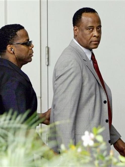 Michael Jackson's physician, Conrad Murray, right, arrives for his arraignment at the Airport...