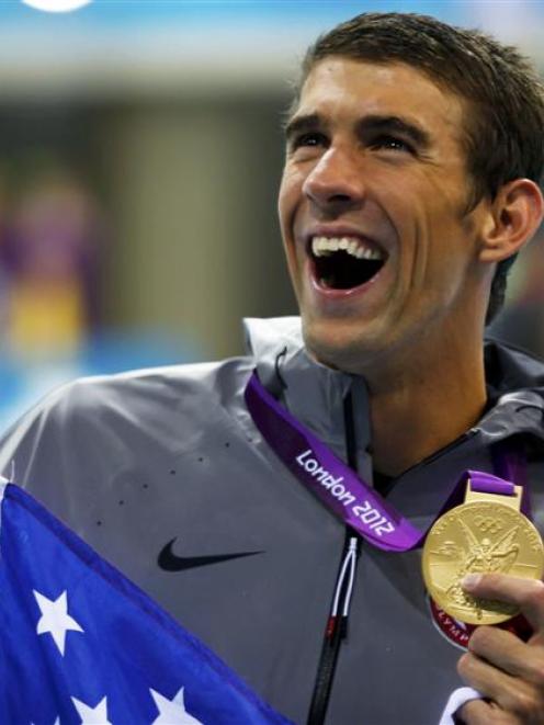 Michael Phelps holds the gold medal he won as part of the men's 4x200m freestyle relay team at...