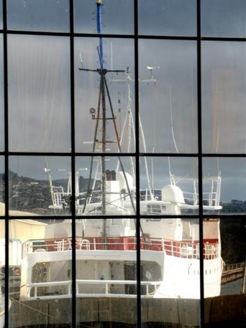Michael Swann's vessel Townsend Cromwell, berthed at Dunedin's Birch St wharf, reflected in the...