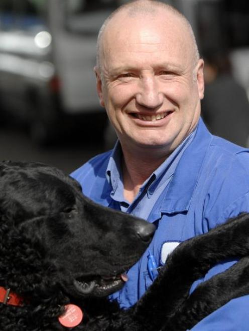 Mike Teasdale gets a cuddle from his curly coated retriever Wilson yesterday. Photo by Linda...