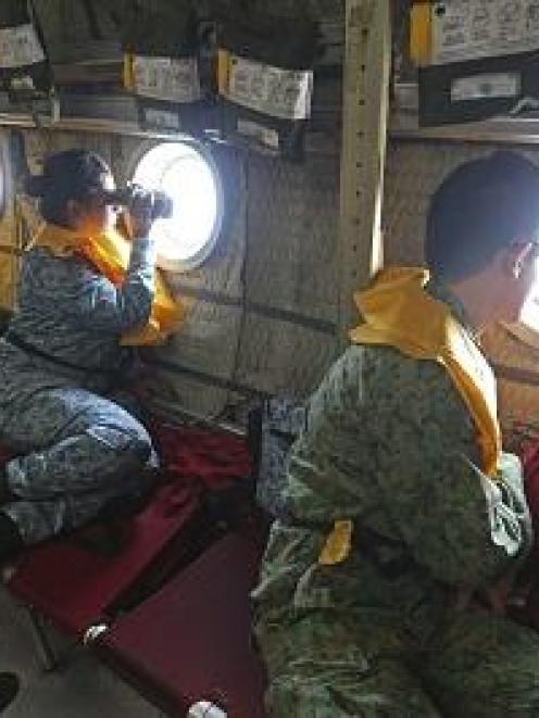 Military personnel search for the missing Malaysia Airlines MH370 plane.