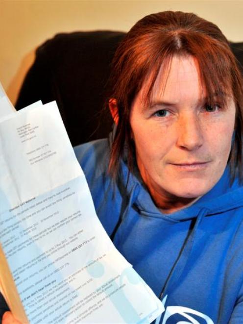 Milton process worker Danelle Byrne holds several IRD letters demanding she file an overdue GST...