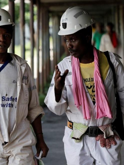 Miners walk at the end of their shift at the Anglo Platinum's Khuseleka shaft 1 mine in...