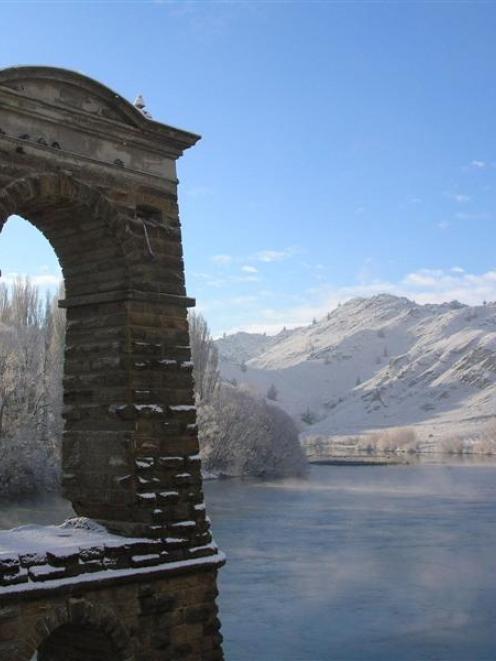 Mist rises off the Clutha River next to one of the old bridge piers in Alexandra during winter....