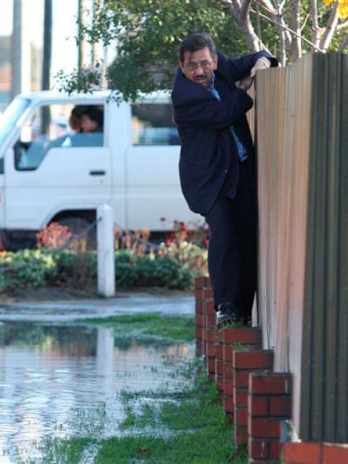 Mohammad Afzli tries to avoid water and liquefaction on Pages Rd. Photo by <i>The Star</i>,...