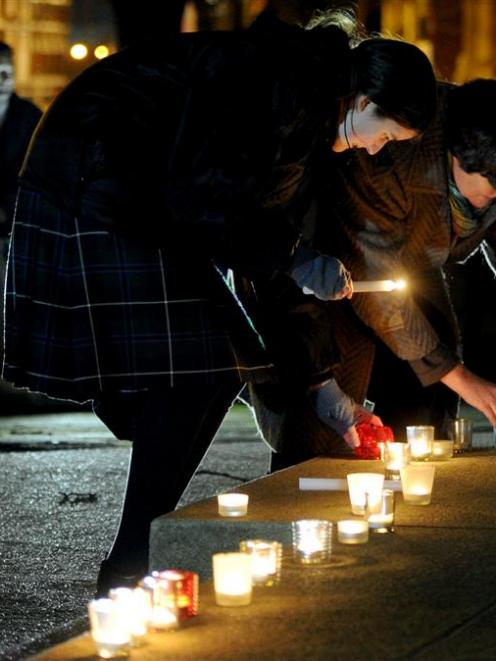 Moira Thomson (left) and the Rev Anne Thomson, of First Church, place candles at a peace vigil at...