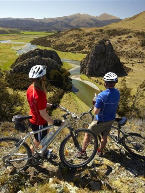 Mountain bikers take in the view from what will be part of the  Around the Mountains Cycle Trail....