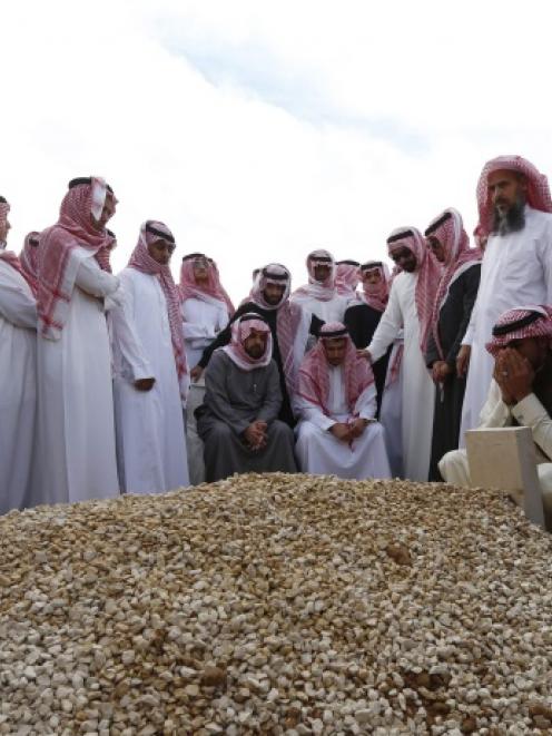 Mourners gather around the grave of Saudi King Abdullah following his burial in Riyadh. Photo by...