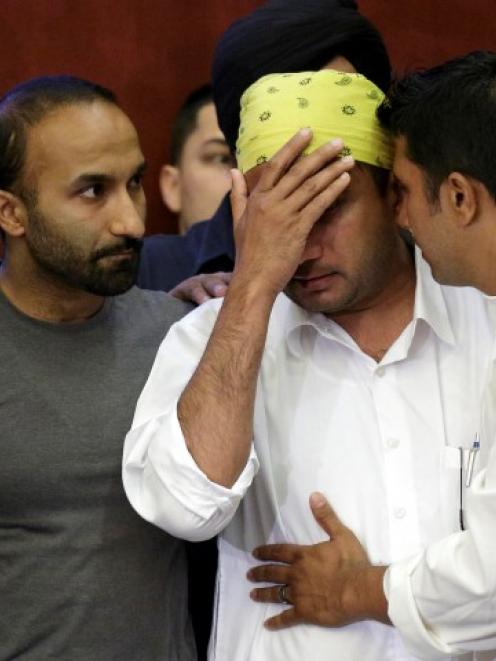 Mourners including Amardeep Kaleka (R), whose father, temple president Satwant Kaleka was one of...