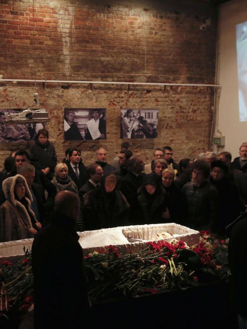Mourners surround a coffin as they attend a memorial service before the funeral of Russian...