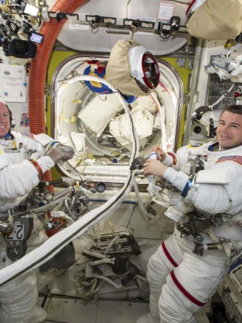NASA astronauts Reid Wiseman (R) and Barry Wilmore work inside the International Space Station....