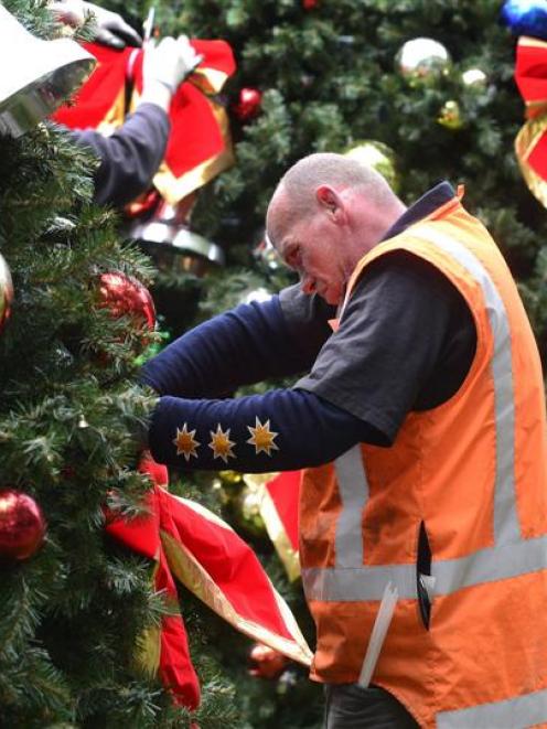 Nate Cummings of Dunedin applying the decorations to the Octagon Christmas Tree before going up...