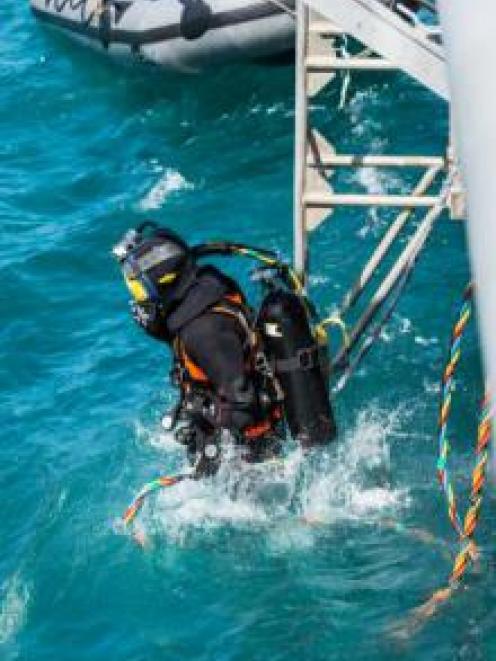 Navy diver ADR Kyran Bennett enters the water in Akaroa Harbour during training preparation for...