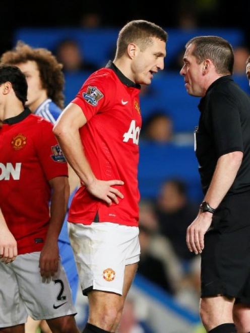 Nemanja Vidic (C) talks with referee Phil Dowd after being sent off. REUTERS/Stefan Wermuth
