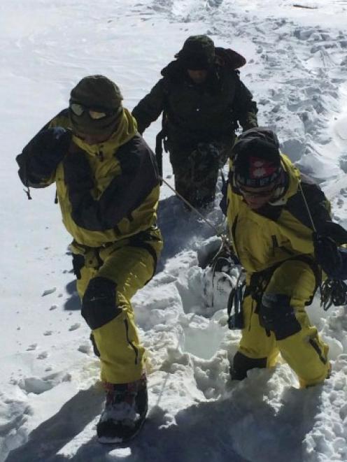 Nepalese army personnel drag the bodies of victims recovered after an avalanche at Thorang-La in...