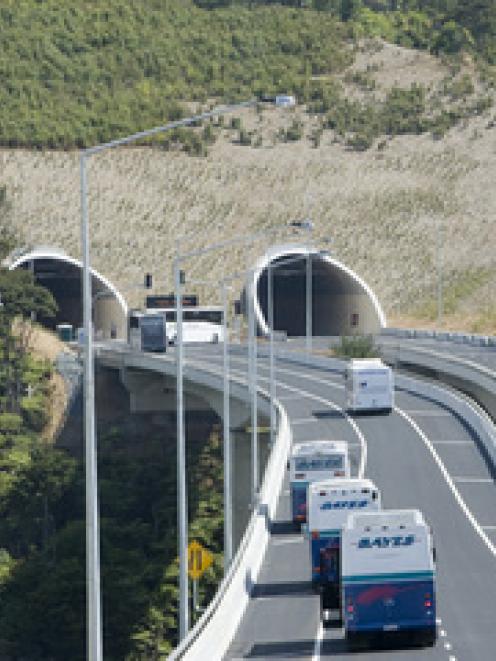 Coaches carrying officials travel along SH 1, Northern Gateway Toll Road at its official opening,...